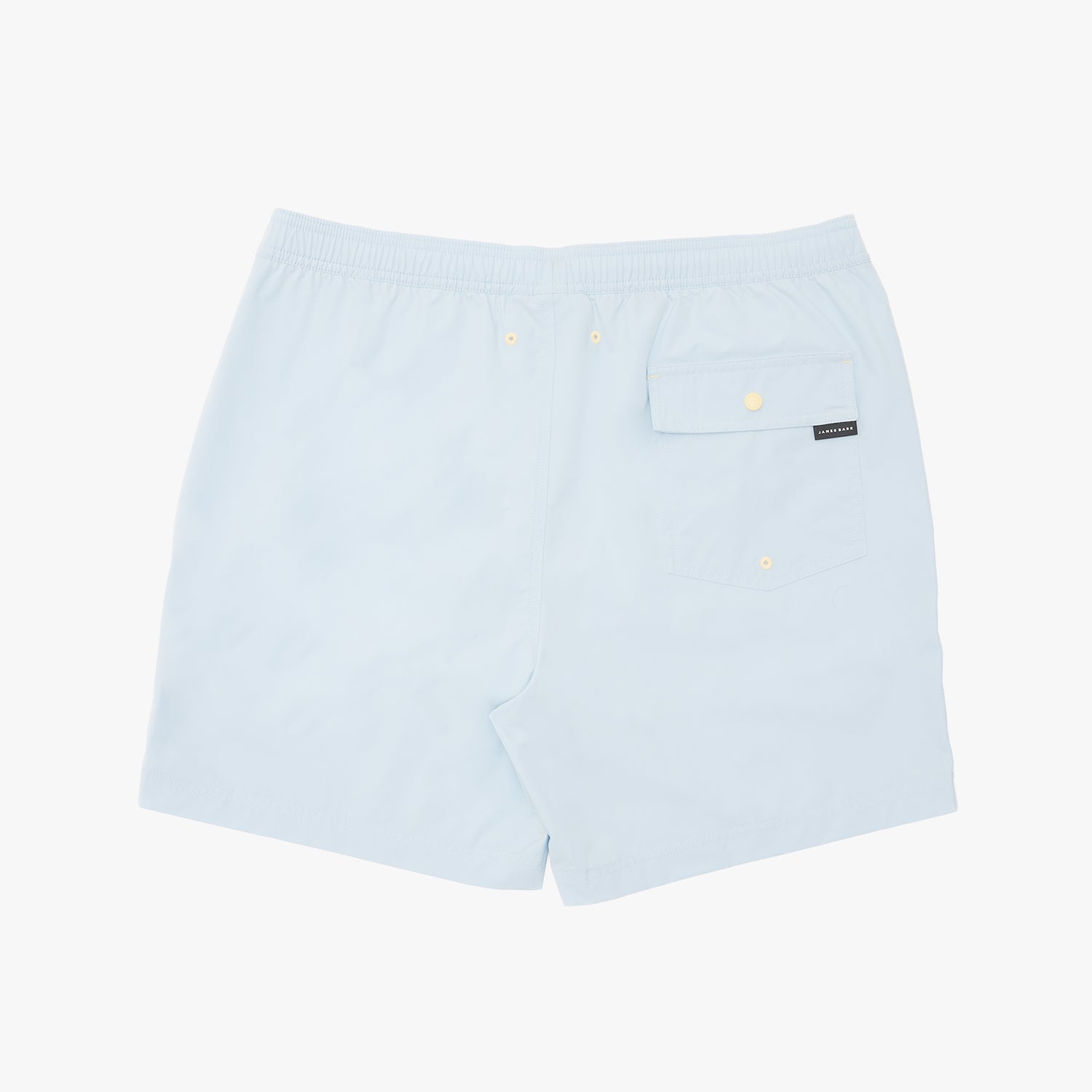 Light blue swim shorts with an elastic waistband, a side pocket with a snap button, and a small black brand tag
