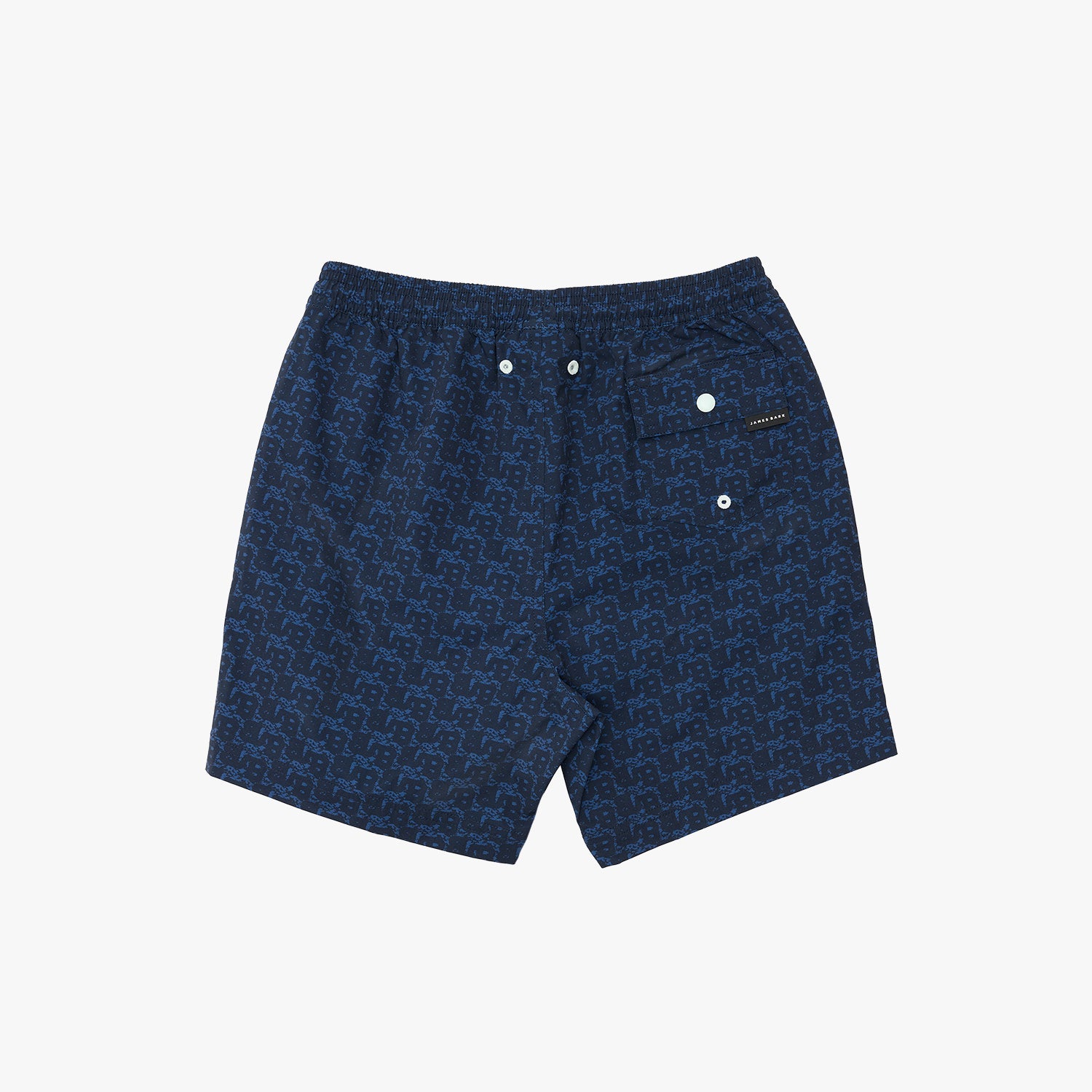 A pair of men's swim trunks featuring a dark blue and navy geometric monogram pattern, with a white snap-button waistband and a small brand patch on the side pocket