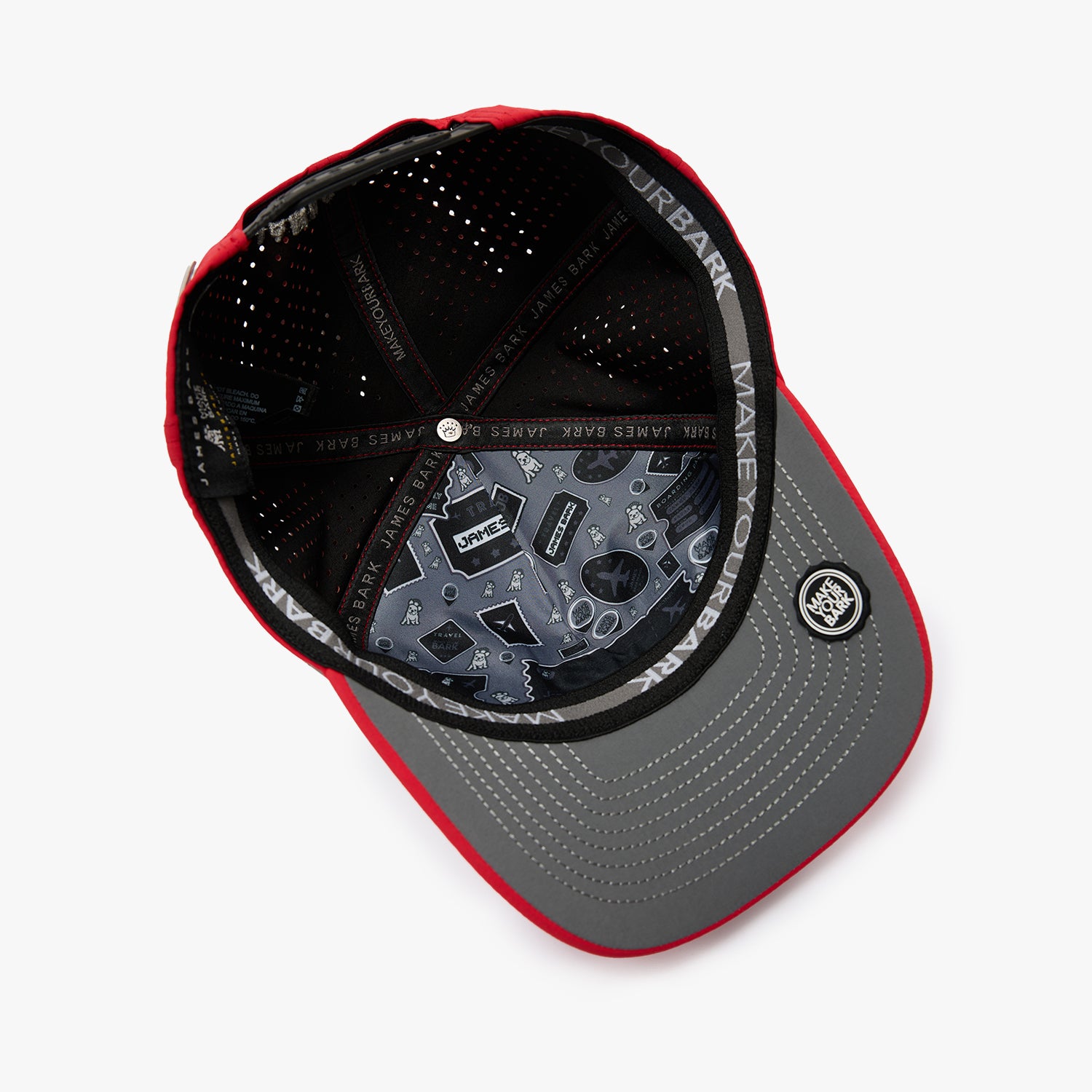 An overhead view of a structured baseball cap with a red and gray color-blocked design. The cap features a black mesh back, a gray visor with red piping, and a circular patch on the side