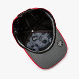 An overhead view of a structured baseball cap with a red and gray color-blocked design. The cap features a black mesh back, a gray visor with red piping, and a circular patch on the side