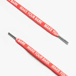 Close up of red shoelaces with the text MAKE YOUR BARK