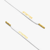 Close-up of white shoelaces with gold aglets and "Jetsetter" text