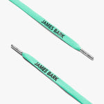 Close-up of turquoise shoelaces with silver aglets and "James Bark" text