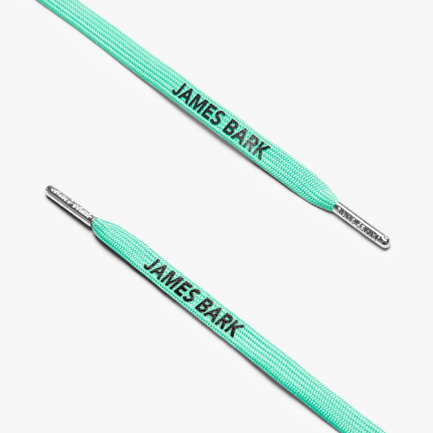 Close-up of turquoise shoelaces with silver aglets and "James Bark" text