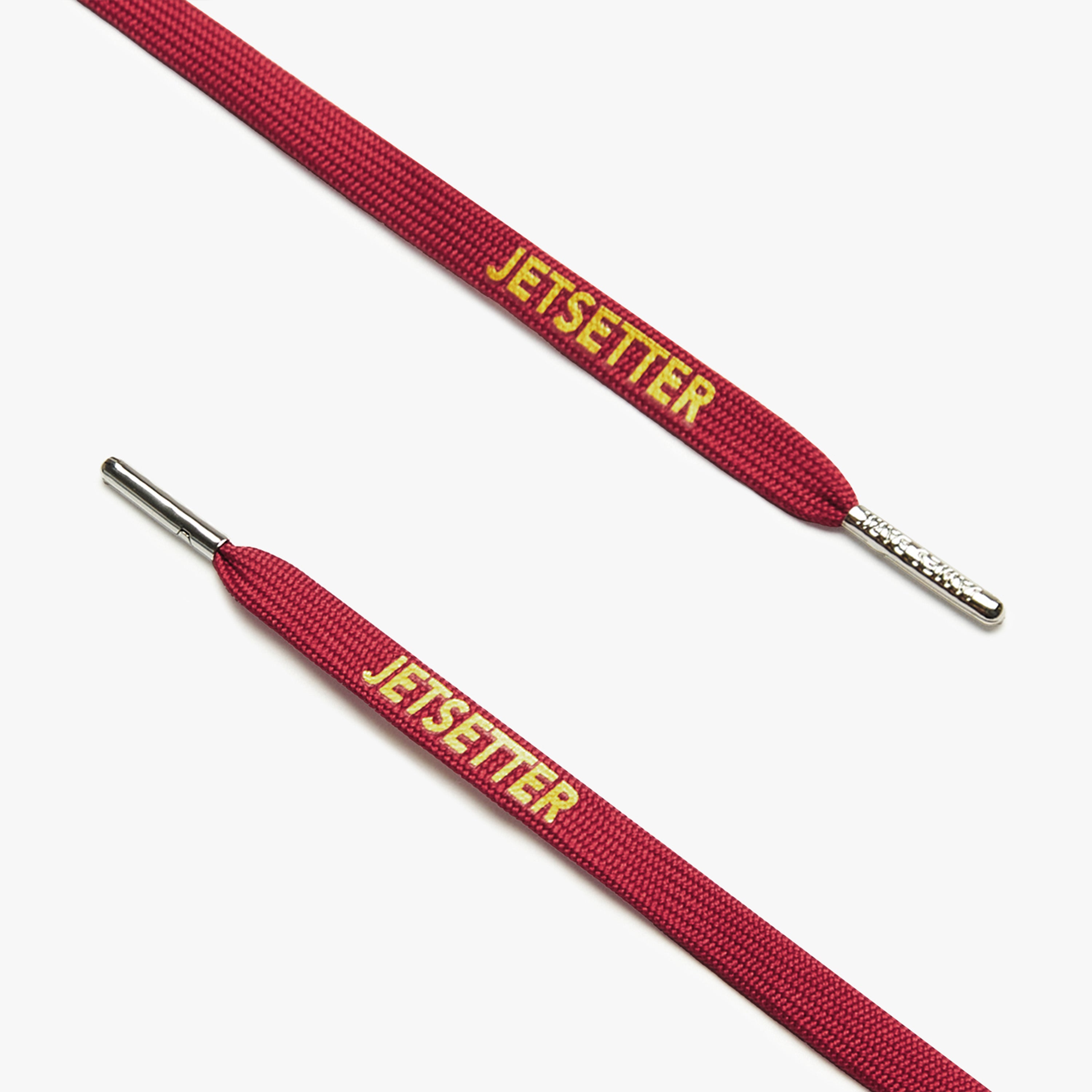 Close-up of maroon shoelaces with silver aglets and "Jetsetter" text