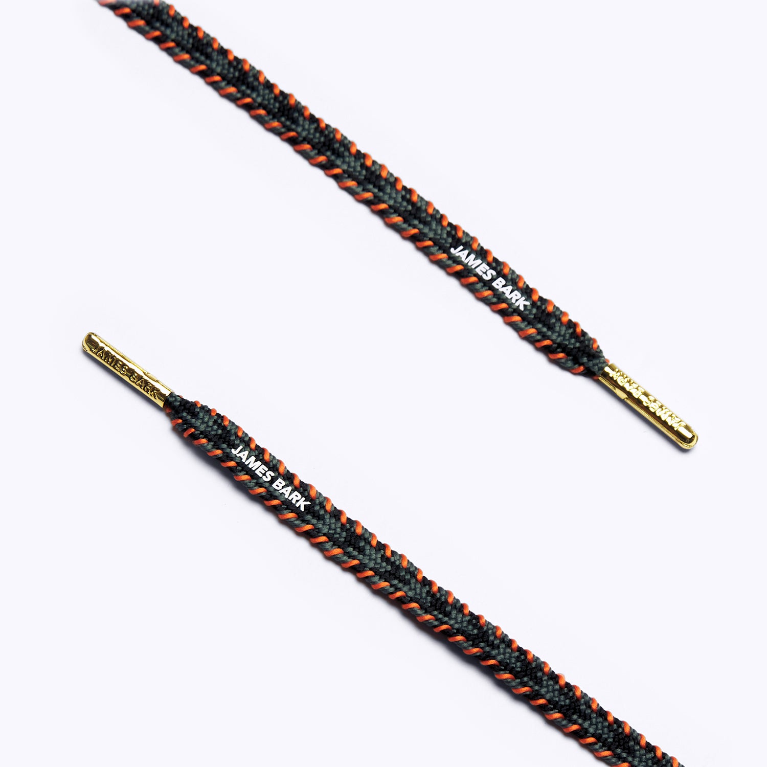 Close-up of black, grey and orange patterned shoelaces with golden aglets and "James Bark" text