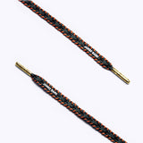 Close-up of black, grey and orange patterned shoelaces with golden aglets and "James Bark" text