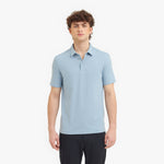 Man wearing a light blue polo shirt on a white background