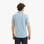 Person wearing a light blue polo shirt on a white background