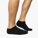 Black ankle socks worn by a person on a white background