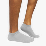 Gray ankle socks worn by a person on a white background