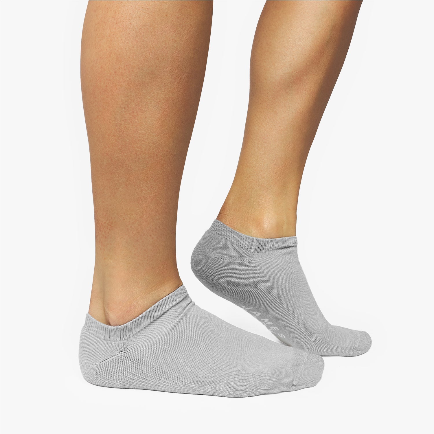 Gray ankle socks worn by a person on a white background