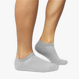 Gray ankle socks worn by a person on a white background