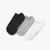 Three pairs of socks in black, gray, and white on a light gray background