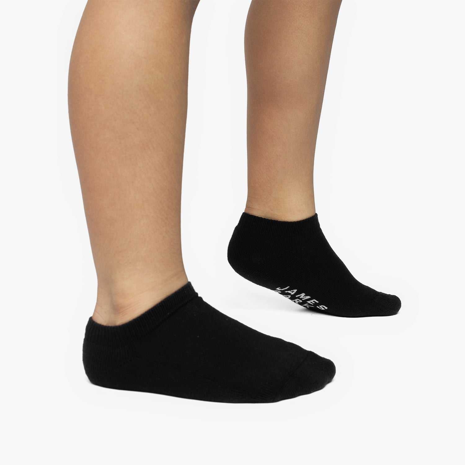 Black ankle socks worn by a person on a white background