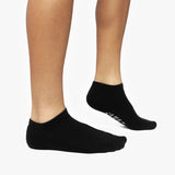 Black ankle socks worn by a person on a white background
