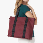 Close-up detail of the burgundy tote bag hanging on a model's shoulder