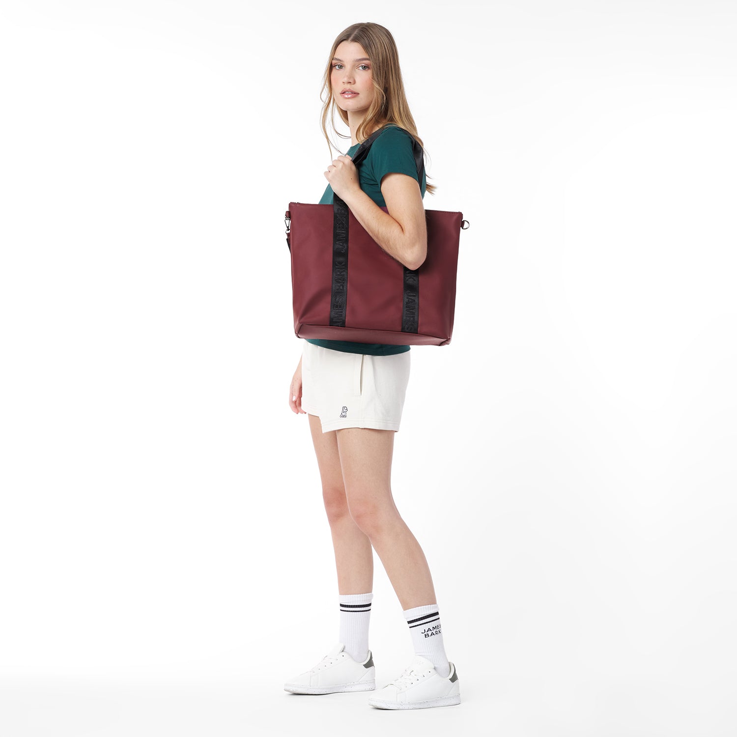 Side view of a model carrying the burgundy James Bark tote bag over her shoulder