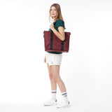 Side view of a model carrying the burgundy James Bark tote bag over her shoulder