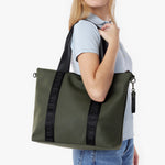 Woman holding a green tote bag with 'James Bark' branding on a white background