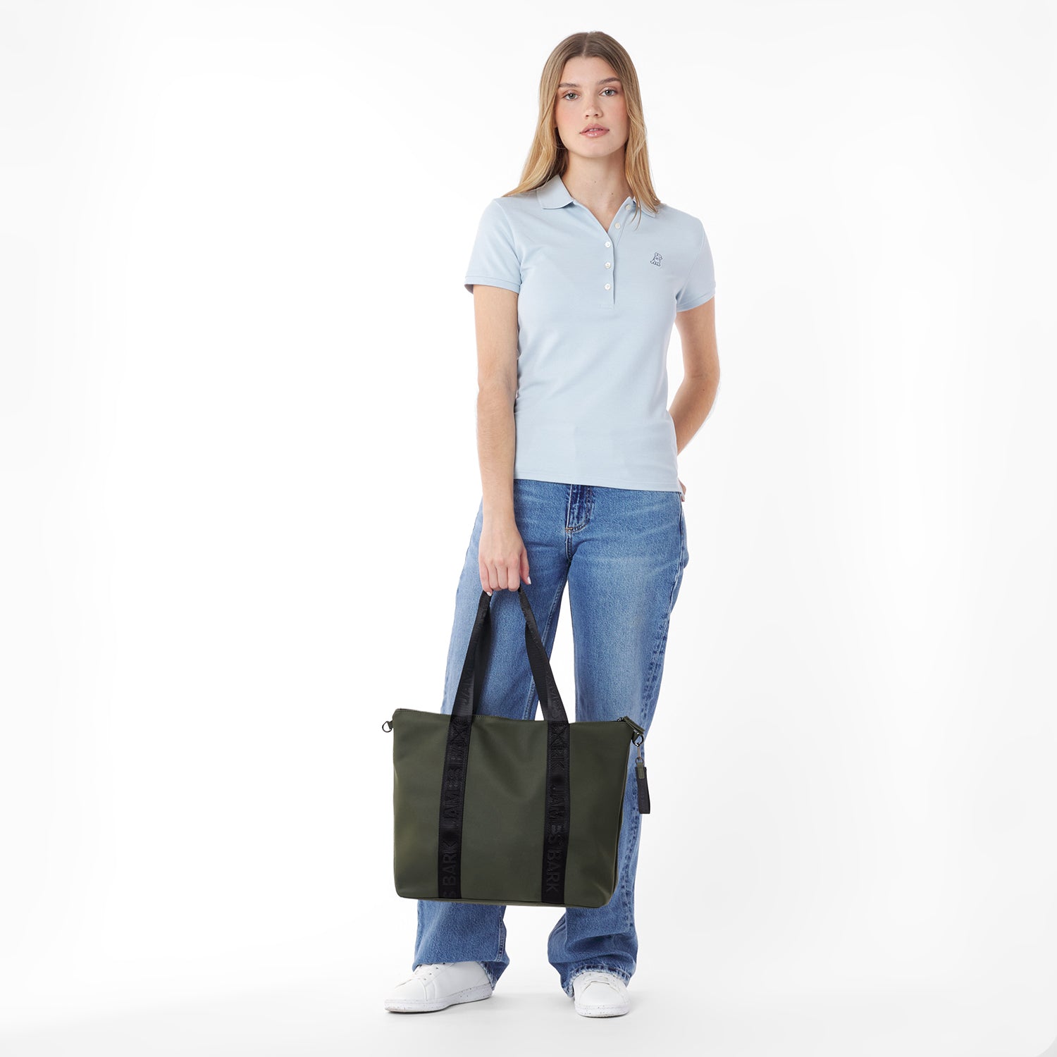 Woman holding a green tote bag against a white background