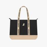 The James Bark tote bag in black with a tan bottom panel and matching tan branded straps