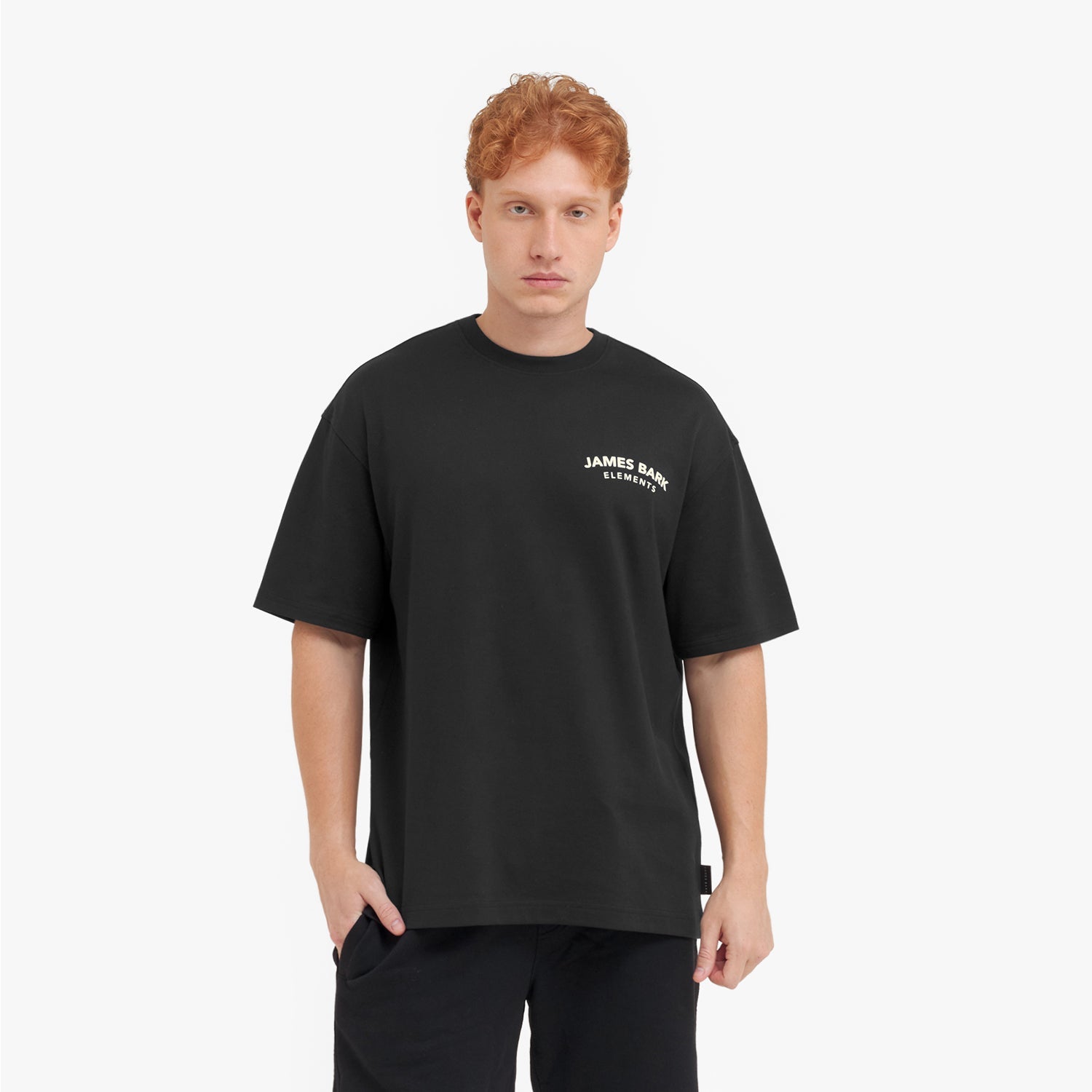 Man wearing a black t-shirt with a brand logo on a white background