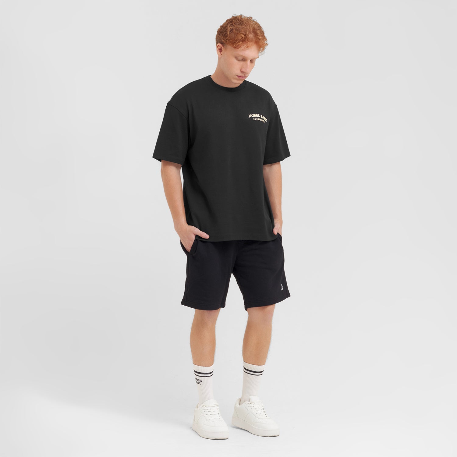 Person wearing a black t-shirt and shorts with a logo on a white background