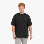 Man wearing a black t-shirt with a small logo on a white background