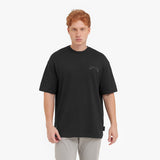 Man wearing a black t-shirt with a small logo on a white background