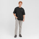 Man wearing a black t-shirt and gray pants on a white background