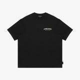 Front view of a black t-shirt laid flat, featuring a small "JAMES BARK ELEMENTS" logo in off-white on the chest