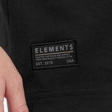Close-up of a black jacket with 'Elements' brand label.