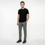 Man wearing a black t-shirt and gray pants on a white background