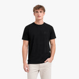 Man wearing a black t-shirt and light-colored pants on a white background