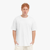 Man wearing a plain white t-shirt and pants on a white background