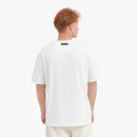 Back view of a man wearing a white t-shirt on a plain background
