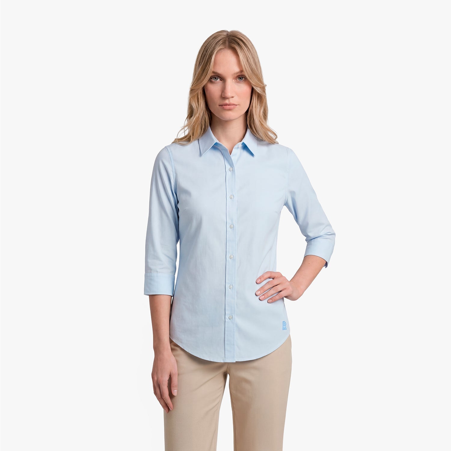 Woman wearing a light blue button-up shirt and beige pants on a white background