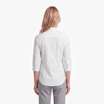 Woman wearing a white shirt and gray pants on a white background