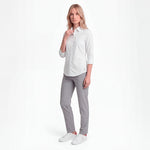 Woman wearing a white shirt and gray pants on a white background