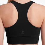Black sports bra on a person with a plain background