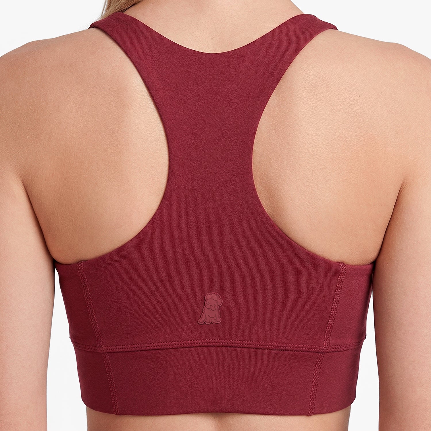 Maroon sports bra with open back on a neutral background