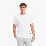 Man wearing a white t-shirt and light gray pants on a white background