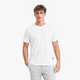 Man wearing a white t-shirt and light gray pants on a white background