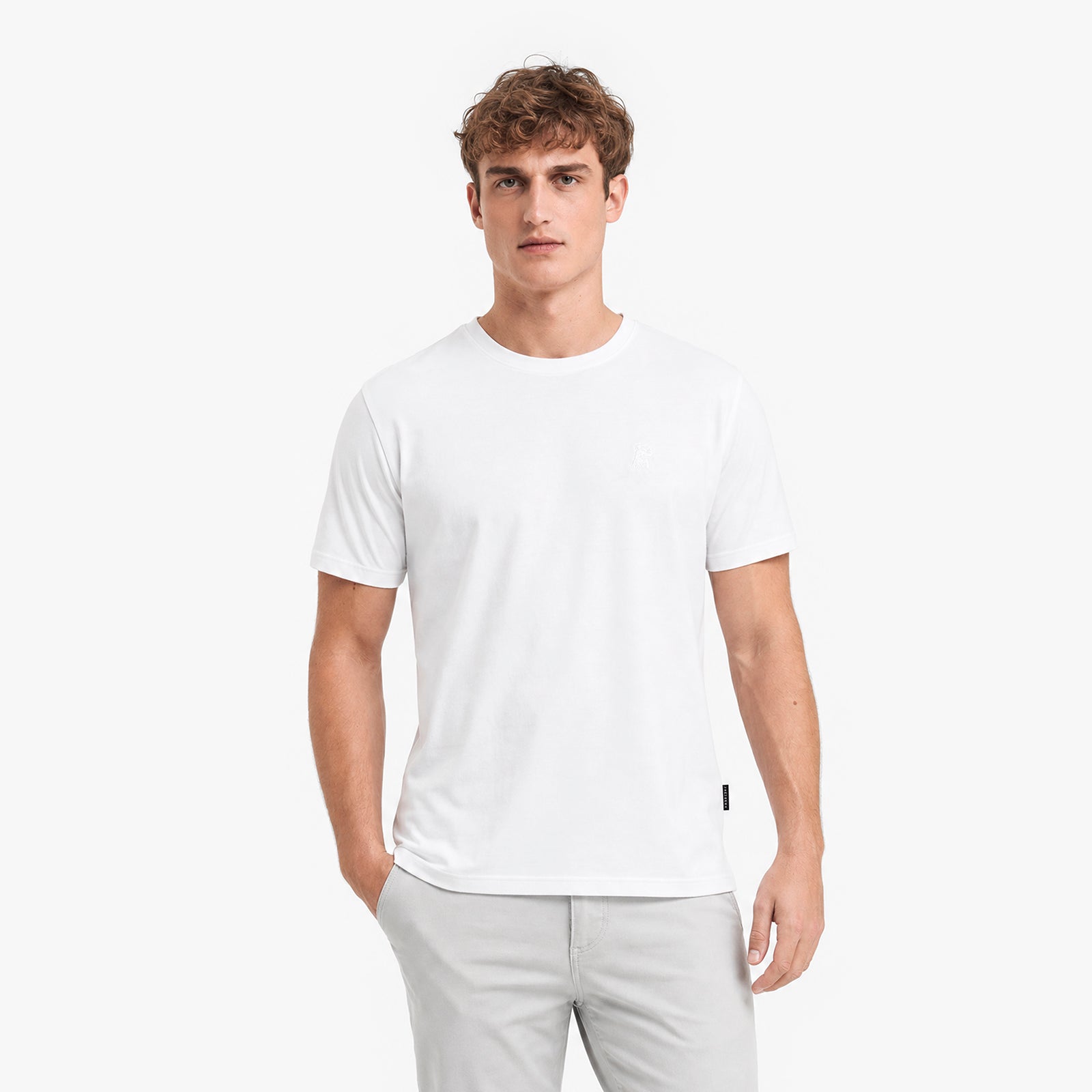 Man wearing a white t-shirt and light gray pants on a white background