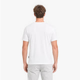 Man wearing a plain white t-shirt and light gray pants on a white background