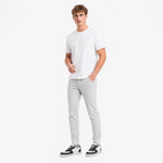 Man wearing a white t-shirt and light gray pants on a white background