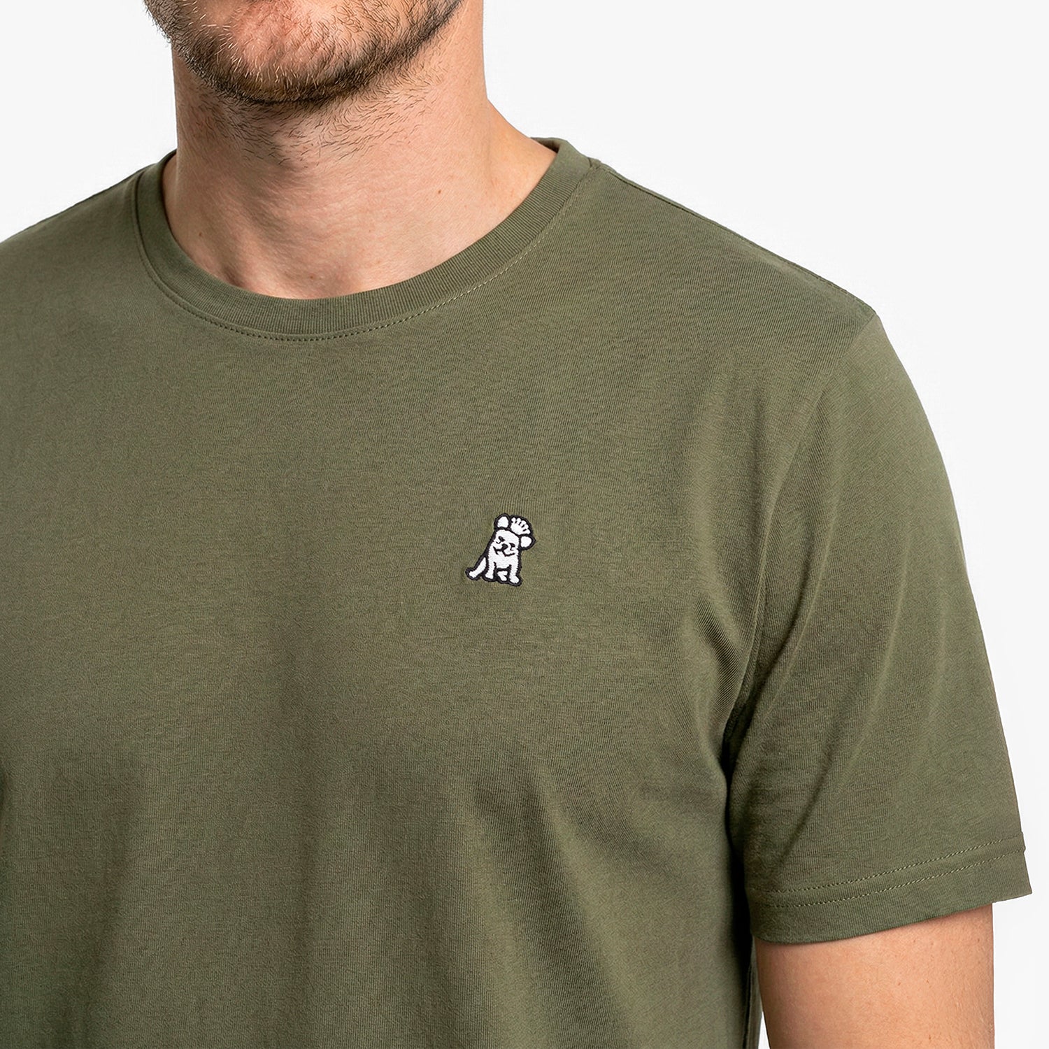 Close-up of a green t-shirt with a small logo on a plain background