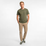 Man wearing a green t-shirt and beige pants on a white background