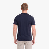 A man viewed from behind wearing a dark navy blue short-sleeve crewneck t-shirt